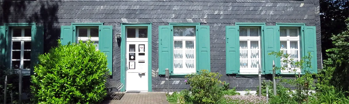 Bild des Gemeindesbüros Querformat. Frontansicht des Eingangs an einem sonnigen Tag.